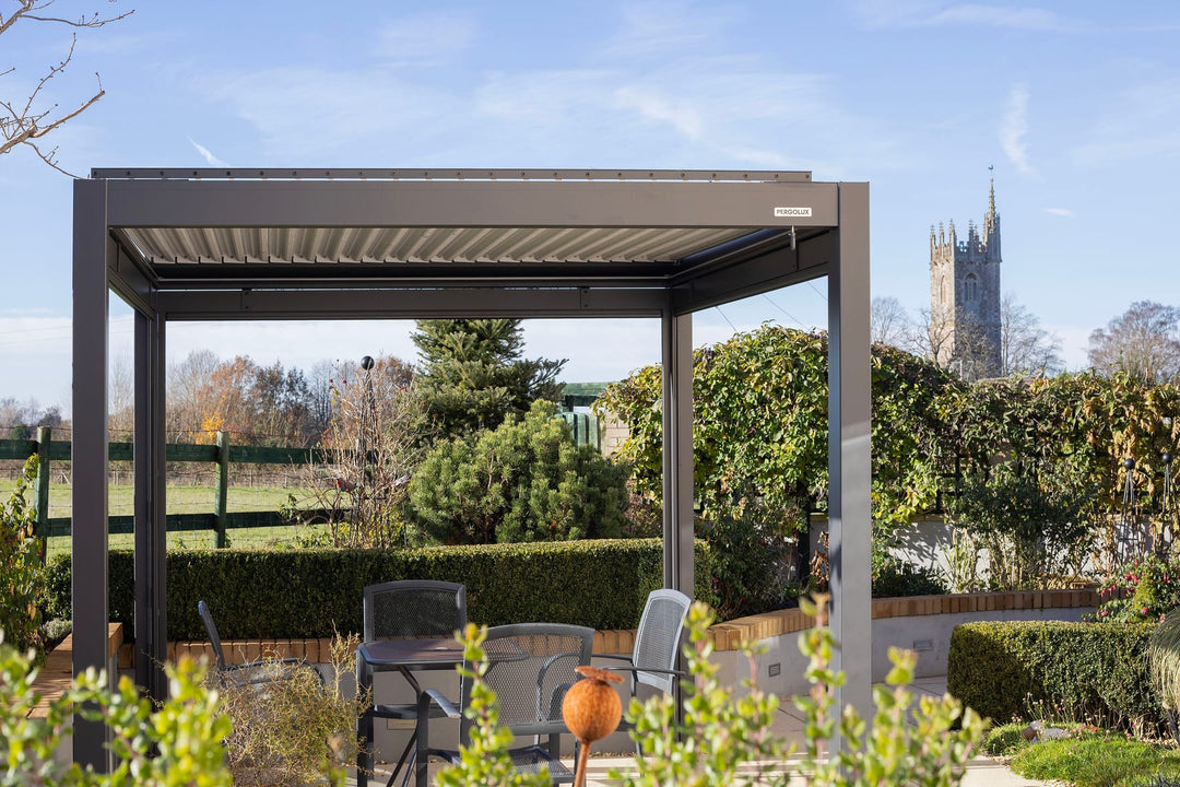 Deux personnes installant les poteaux d'une Pergola 4 Pro sur une terrasse ensoleillée, niveau à bulle en main
