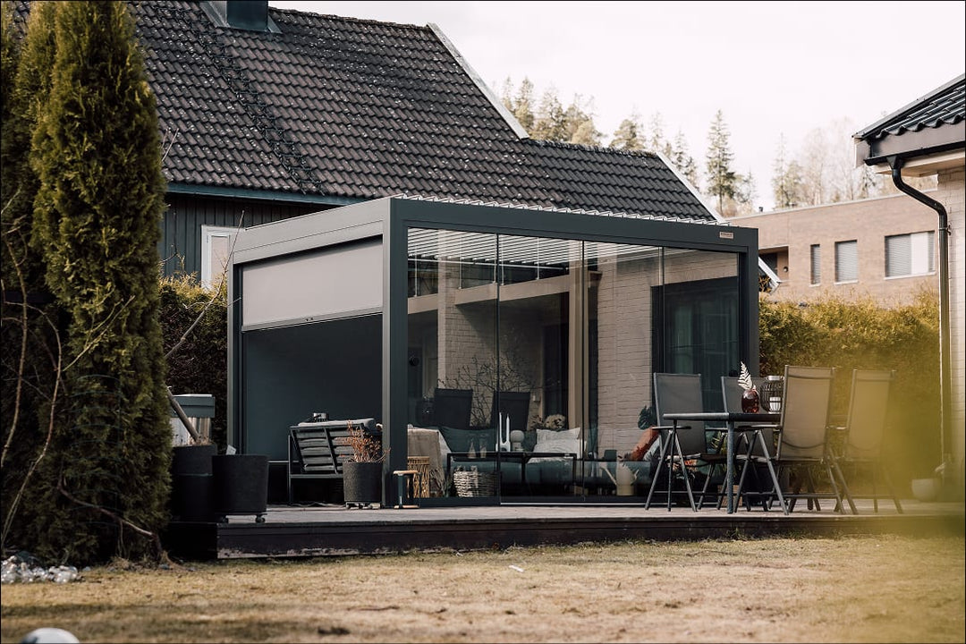 Pergola 4 Pro en aluminium anthracite installée sur une terrasse parisienne, lames ouvertes à 130° sous un ciel dégagé de printemps