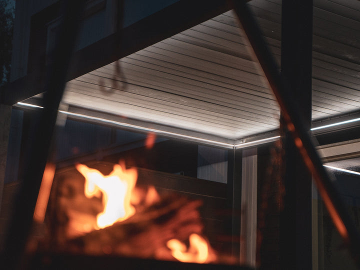 Pergolux Pergola med Pergolux LED lys, varm hvit. Bålpanne flamme i forgrunnen.